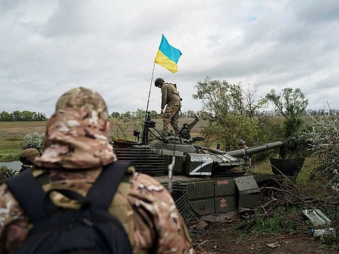 A Ukrainian national guard serviceman stands atop a destroyed Russian tank in an area near the border with Russia, in Kharkiv region, Ukraine, Monday, Sept. 19, 2022.