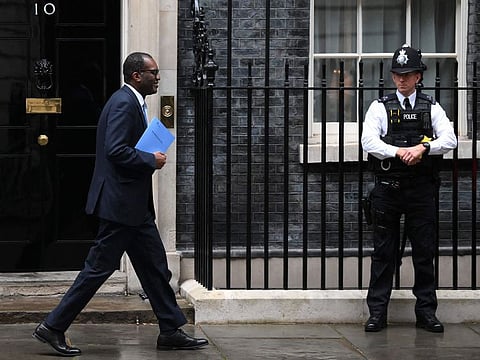 Britain's Chancellor of the Exchequer Kwasi Kwarteng holds a folder reading "The Growth Plan 2022" as he walks past Number 10 Downing Street on his way to unveil an anti-inflation budget plan in London on September 23, 2022