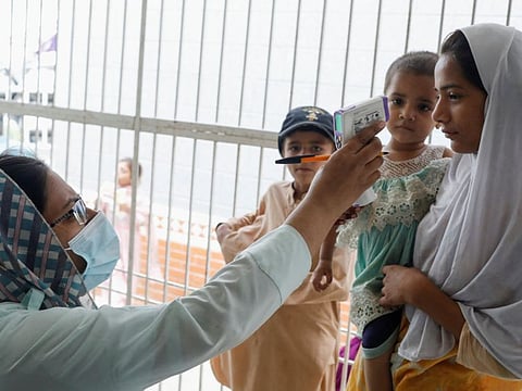 Children receive medical assistance as their families take refuge in a school, following rains and floods during the monsoon season, in Karachi, Pakistan September 22, 2022.