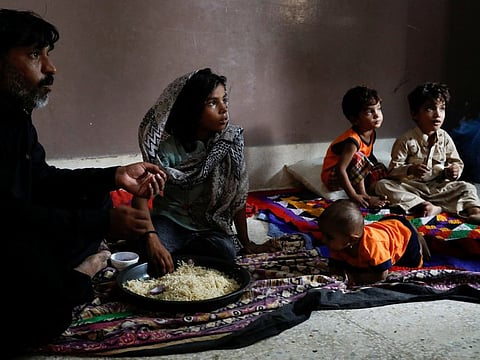 Eight year-old Sara, displaced because of the floods, eats lunch with her father, while they take refuge in a school, following rains and floods during the monsoon season, in Karachi, Pakistan September 23, 2022.