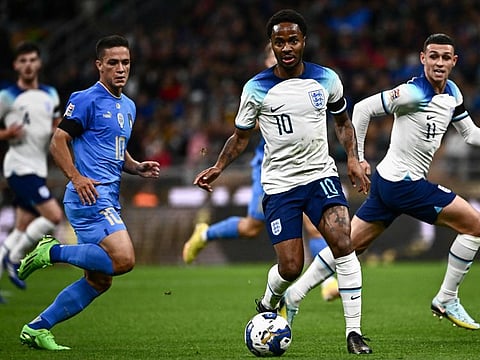 England's forward Raheem Sterling (centre) runs with the ball as Italy's midfielder Giacomo Raspadori (left) looks on during the UEFA Nations League's League A Group 3 match at the San Siro Stadium in Milan.