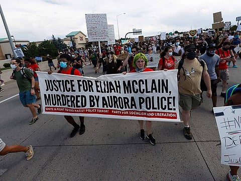 Demonstrators move along Interstate 225 after stopping traffic during a rally and march over the death of 23-year-old Elijah McClain, Saturday, June 27, 2020, in Aurora, Colorado.