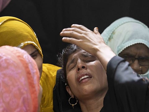Relatives mourn by the body of Mohammad Usman, 15, who was killed by lightning on Friday at Prayagraj, in the northern Indian state of Uttar Pradesh, on September 24, 2022.