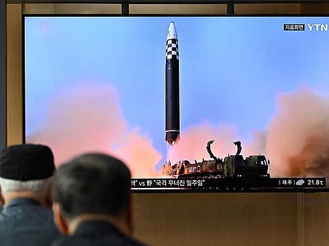 File photo: People watch a television screen showing a news broadcast with file footage of a North Korean missile test, at a railway station in Seoul on September 25, 2022.
