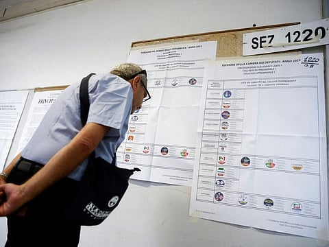 A man looks at a list of names of candidates at a polling station during the snap election, in Rome, Italy, September 25, 2022.