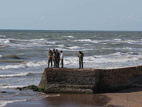 Military personnel stand near the sea shore following the sinking of a migrant boat off the Syrian coast on Thursday after sailing from Lebanon, as pictured from the Lebanese-Syrian border crossing in Arida, Lebanon September 23, 2022.