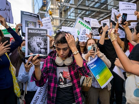 Activist Forouzan Farahani shaves her head in protest over the death of Mahsa Amini in Iran outside The New York Times building in New York City on September 27, 2022.