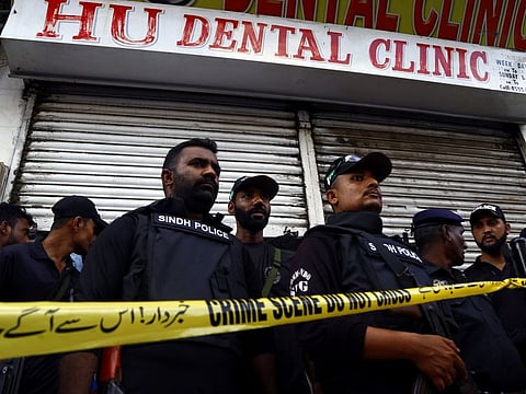 Police officers stand guard at a clinic in Karachi where the shooting happened on September 28.