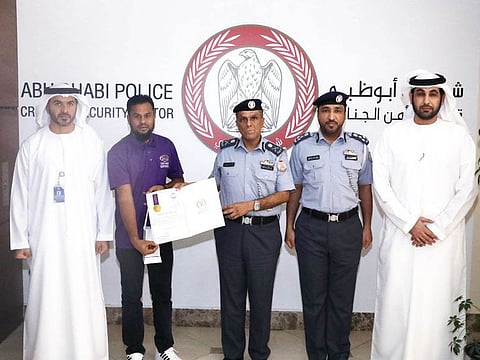 Abu Dhabi Police officials honouring an Asian expat for his honesty after he handed over a sum of money to police