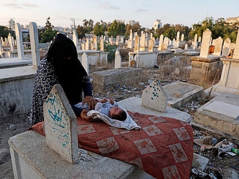 Kamilia Kuhail, 35, looks after her 2 month old son, Ahmad, in the Sheikh Shaban cemetery where she lives with her family, in Gaza City.