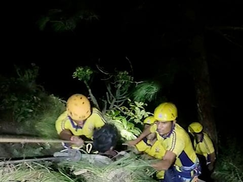 Rescuers pull out a passenger from a bus that fell into a gorge in Pauri district in the northern state of Uttarakhand.