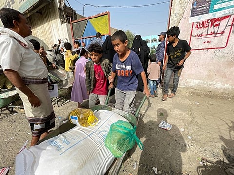 A boy pushes a wheel cart with wheat flour, cooking oil and beans at an aid distribution centre in Sana'a, Yemen September 28, 2022.