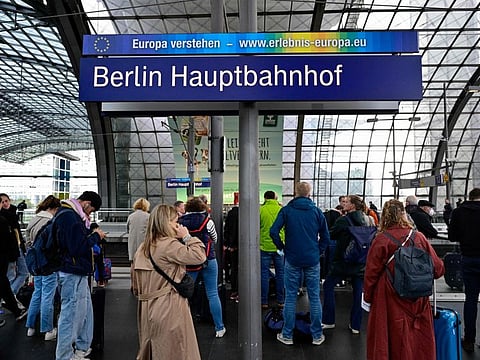 Passengers wait for a train on a platform at the main train station in Berlin on October 8, 2022 following major disruption on the German railway network.