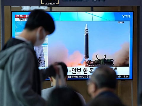 A TV screen showing a news program reporting about North Korea's missile launch with file footage.
