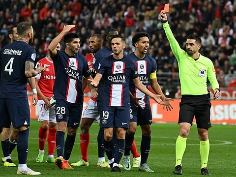 Sergio Ramos (left) receives a red card from referee Pierre Gaillouste (right) during the French L1 match between Stade de Reims and Paris Saint-Germain at Stade Auguste-Delaune in Reims, northern France.