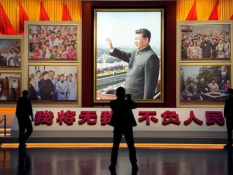 A portrait of Chinese President Xi Jinping is displayed near the words that means "I will put aside my own well-being for the good of my People" at the Museum of the Communist Party of China in Beijing, Wednesday, Oct. 12, 2022.