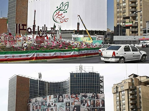 This combination of pictures created on October 14, 2022 shows (above) Iranians driving past past a huge billboard which reads in Persian the women of my land, Iran in Valiasr Square in Tehran, and an image taken on October 13, of a huge billboard showing a montage of pictures titled the women of my land, Iran featuring women who are all with a hijab, on Valiasr Square in Tehran.