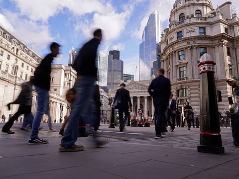 People walk outside the Bank of England, in the financial district known as The City, in London, Friday, Oct. 7, 2022. Truss and her ministers say they want to solve a fractious dispute with the European Union over post-Brexit trade rules.(AP Photo/Alberto Pezzali)