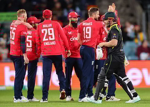 Englands Chris Woakes (centre) celebrates with teammates after dismissing Australian captain Aaron Finch during the third Twenty20 match at Manuka Oval in Canberra on Friday.