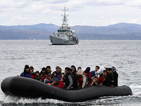 Migrants arrive with a dinghy accompanied by a Frontex vessel at the village of Skala Sikaminias, on the Greek island of Lesbos, after crossing the Aegean sea from Turkey, in a file picture.