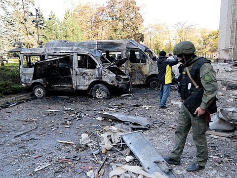 Investigators inspect a site after shelling near an administrative building, in Donetsk on October 16, 2022.