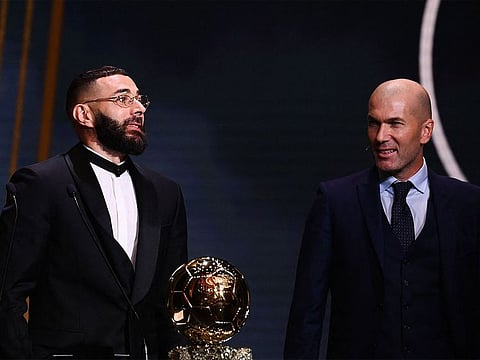 Real Madrid's French forward Karim Benzema receives the Ballon d'Or award from French former forward football player Zinedine Zidane.
