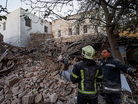 Rescuers stand next to a building heavily damaged by a Russian missile strike, amid Russia’s attack on Ukraine, in Mykolaiv, Ukraine October 18, 2022.