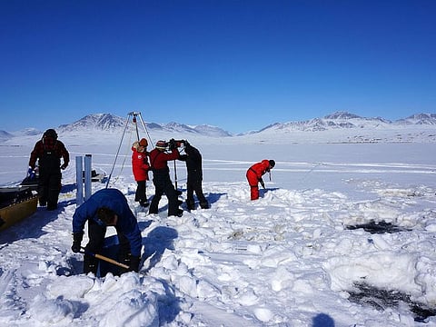 Researchers drilling holes to collect sediment at the Lake Hazen in Nunavut, to investigate how climate change might increase the risk of "viral spillover.