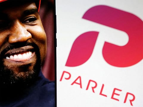American rapper Kanye West's picture is seen on a smartphone next to the logo of social media app Parler in this Illustration taken, October 17, 2022.