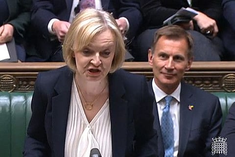 A video grab taken from footage broadcast by the UK Parliament's Parliamentary Recording Unit (PRU) shows Britain's Prime Minister Liz Truss speaking in front of Britain's Chancellor of the Exchequer Jeremy Hunt (back) during Prime Minister's Questions in the House of Commons in London on October 19, 2022.