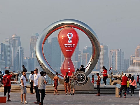 People walking past the Qatar 2022 Fifa World Cup countdown clock as it nears marking thirty days in Doha.