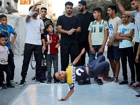 A Palestinian boy performs breakdance at a street in Nusseirat refugee camp in central Gaza Strip.
