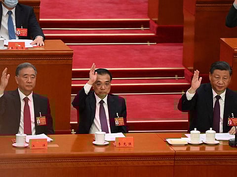 China's President Xi Jinping (right), China's Premier Li Keqiang and Politburo Standing Committee member Wang Yang attend the closing ceremony of the 20th Chinese Communist Party's Congress at the Great Hall of the People in Beijing on October 22, 2022.