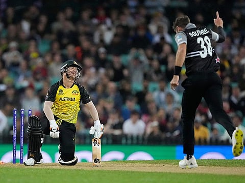 Australia's David Warner reacts after he was out bowled by New Zealand's Tim Southee, right, during the T20 World Cup cricket match between Australia and New Zealand in Sydney, Australia.