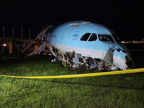 A damaged portion of the Korean Air Lines Co. plane lies after it overshot the runway at the Mactan Cebu International Airport in Cebu.