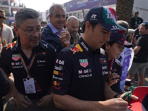 Red Bull driver Sergio Perez of Mexico signs an autograph during the Formula One Mexico Grand Prix at the Hermanos Rodriguez racetrack in Mexico City on Friday.