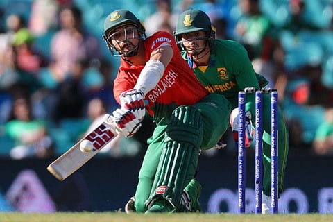 Bangladesh's Nurul Hasan plays a shot in front of South Africa's Quinton de Kock during the ICC men's Twenty20 World Cup 2022 cricket match at the Sydney Cricket Ground in Sydney.