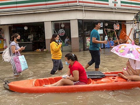 People wade through a flooded street following heavy rains brought by tropical storm Nalgae, in Imus, Cavite.