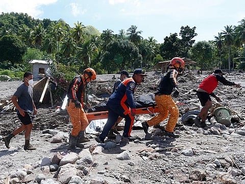 Rescuers carry a body at Maguindanao's Datu Odin Sinsuat town, southern Philippines