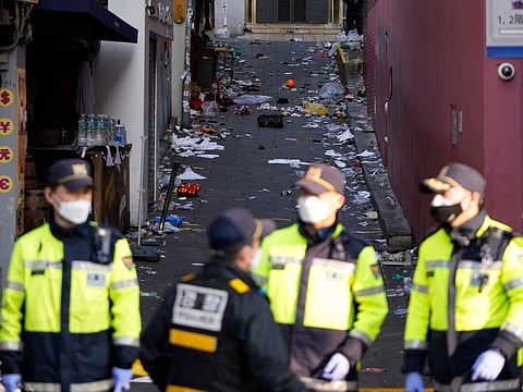 South Korean police officers stand guard at the scene in Seoul, South Korea, Sunday, Oct. 30, 2022.