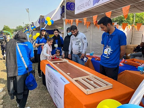 A child plays the popular Dutch game Sjoelen at the Netherlands stall during the EuroVillage event.
