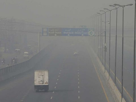 Vehicles drive on a highway as smog envelops the area of Lahore, Pakistan.
