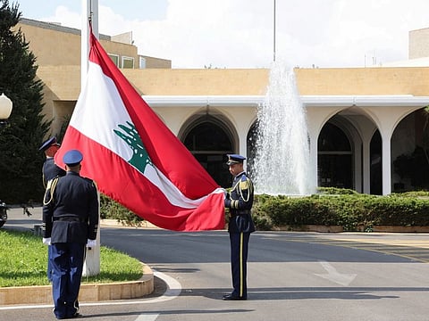 Members of the presidential guards remove a Lebanese flag after former Lebanese President Michel Aoun's six-year term officially ended, at the presidential palace in Baabda, on November 1, 2022.