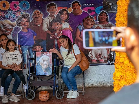Tourists poses for a picture at the house of Maria Salud Ramirez Caballero, known as Mama Coco.