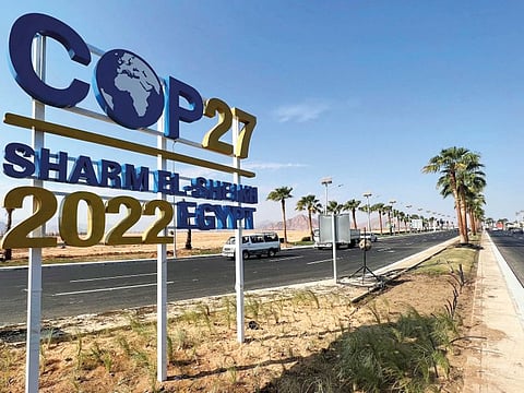 View of a COP27 sign on the road leading to the conference area in Egypt's Red Sea resort of Sharm Al Sheikh town as the city prepares to host the COP27 summit next week, October 20, 2022.