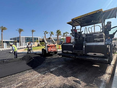 Egyptian workers fix a road with diesel near the conference area in Egypt's Red Sea resort of Sharm Al Sheikh town as the city prepares to host the COP27 summit next week, October 20, 2022.