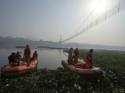 Rescuers on boats search in the Machchhu river next to a cable bridge that collapsed on Sunday in Morbi town of western state Gujarat, India, Wednesday, Nov. 2, 2022.