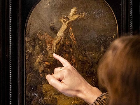 A visitor looks at The Creation of Jesus on the Cross by Rembrandt on display at Museum Bredius in The Hague