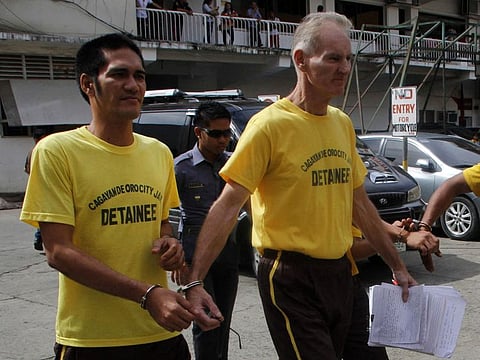 This file photo taken on June 16, 2015 shows Peter Scully of Australia (right) leaving the court handcuffed to another inmate after his arraignment in Cagayan de Oro City, on the southern Philippine island of Mindanao.