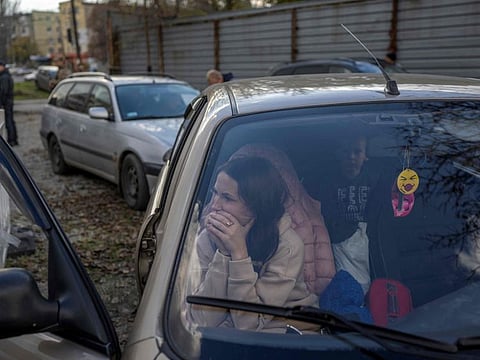 A Ukranian woman sits in a car with her family after they managed to flee from the Russian territory of Kherson, on November 5, 2022, in Zaporizhzhia. (Photo by BULENT KILIC / AFP)